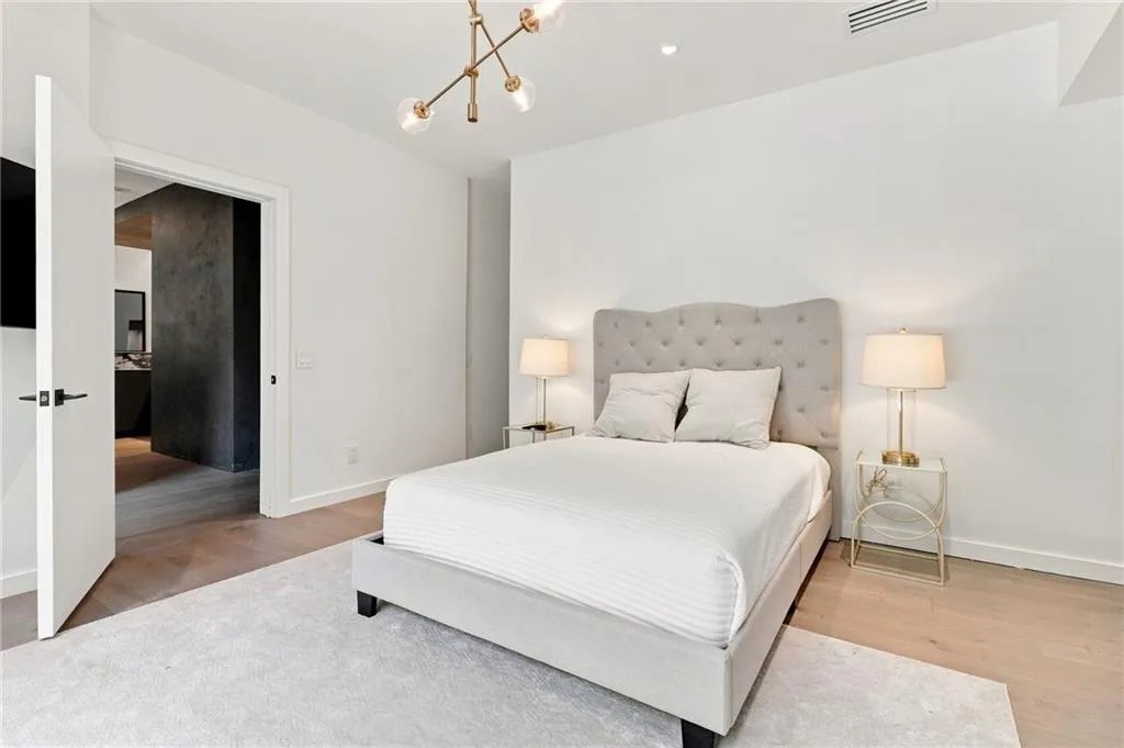 Recessed lighting, wood-finish flooring, and a modern ceiling light fixture