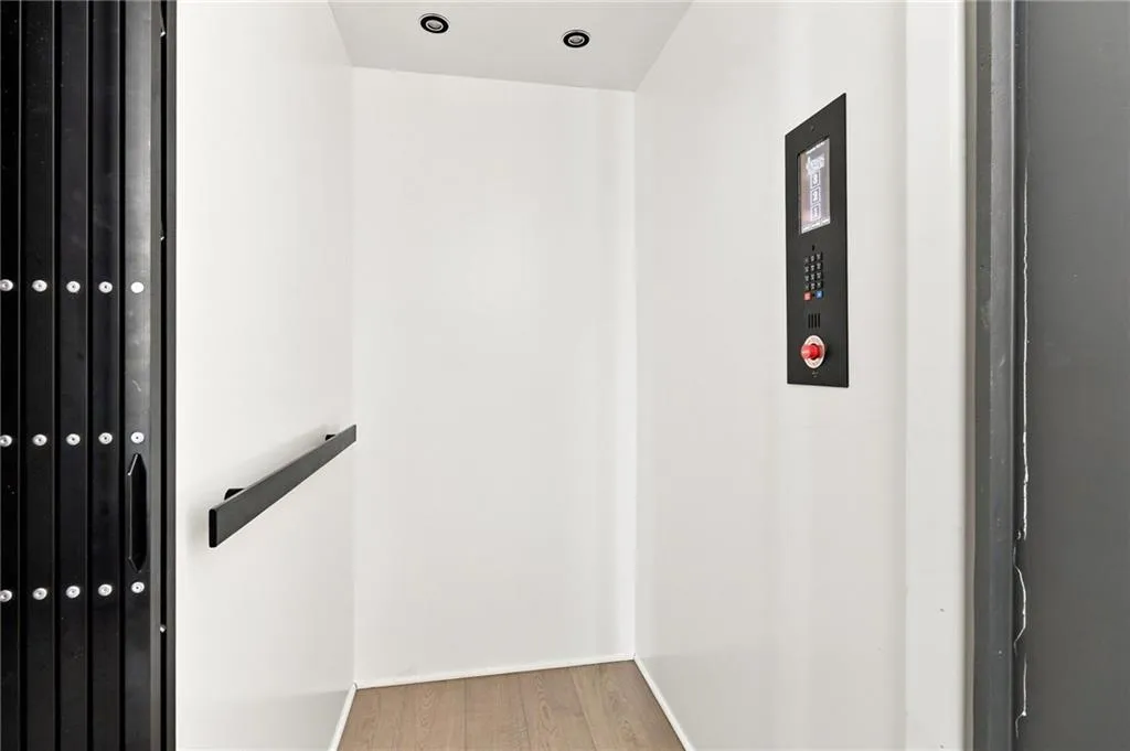 Interior residential elevator featuring recessed lighting and a sleek control panel