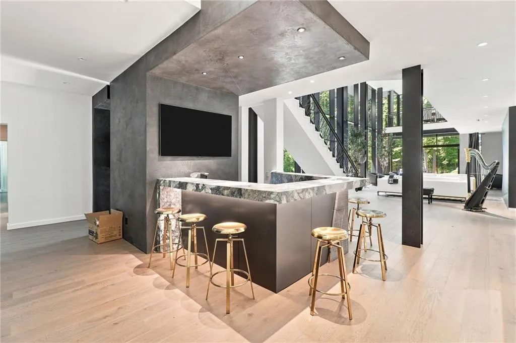 Built-in bar with a stone countertop, light wood-finish flooring, recessed lighting, and a modern staircase with open risers