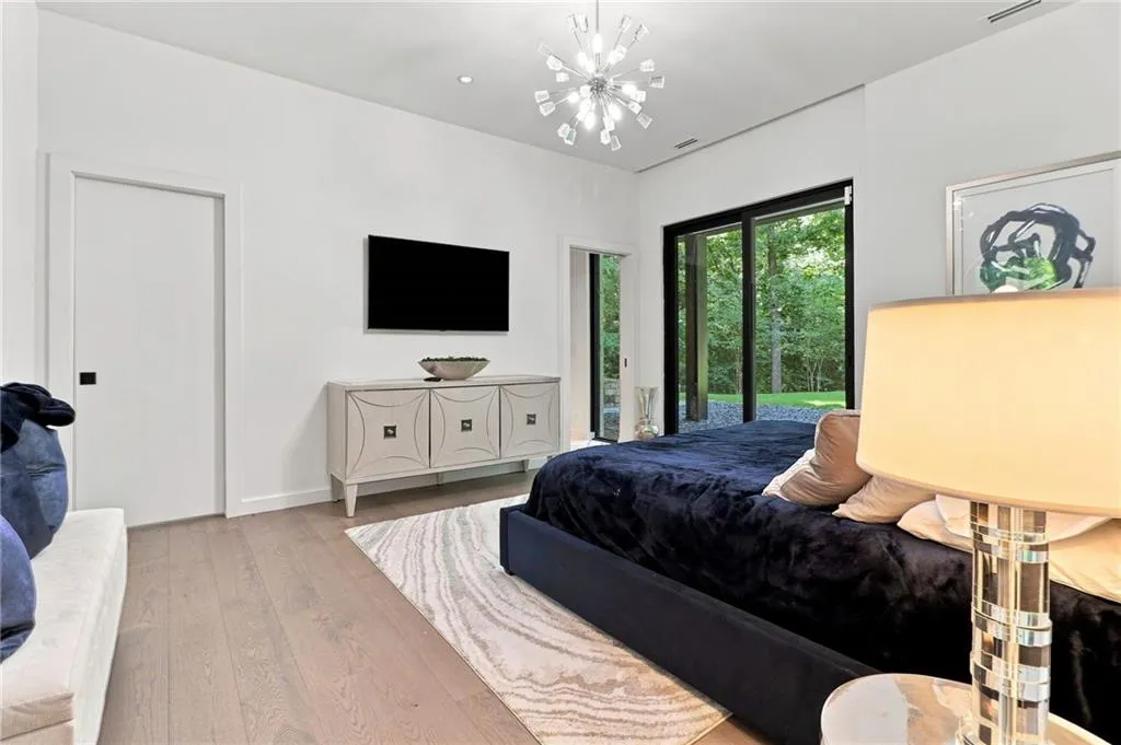 Recessed lighting throughout, wood-finish flooring, a contemporary chandelier, and large sliding glass doors
