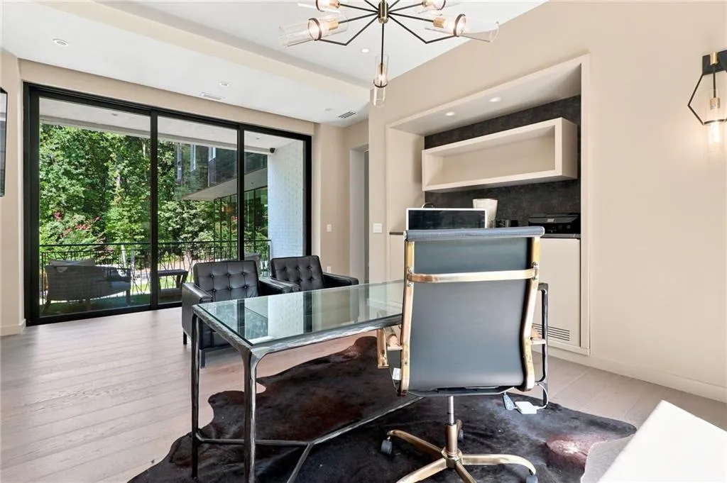 Expansive sliding glass doors, wood-finish flooring, built-in shelving, recessed lighting, and a modern chandelier