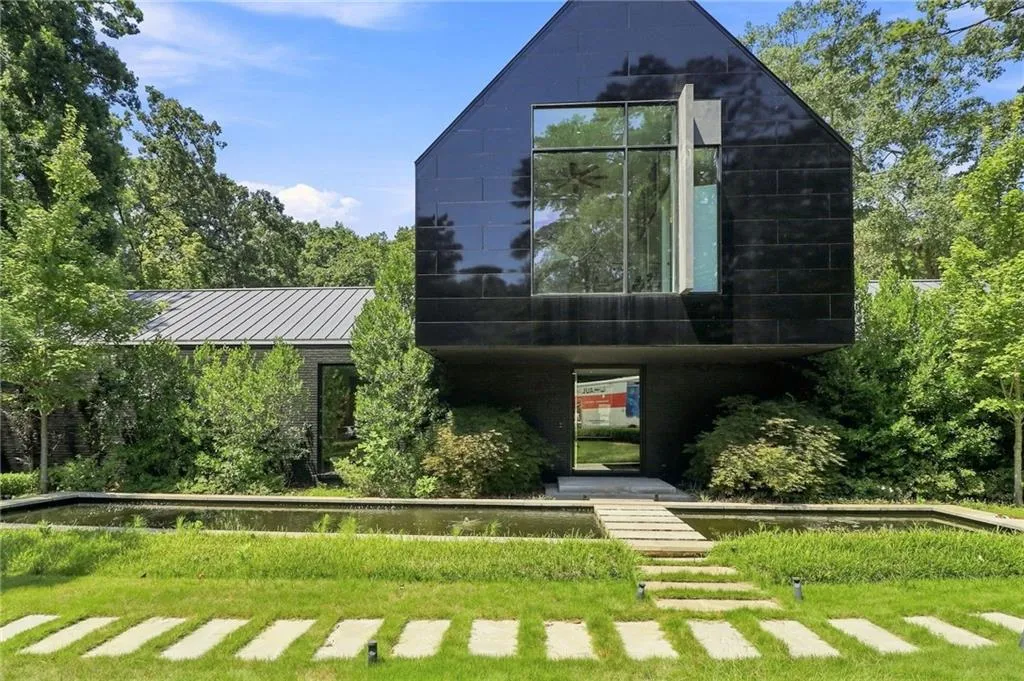 Contemporary exterior with black paneling, prominent window feature, and a metal roof