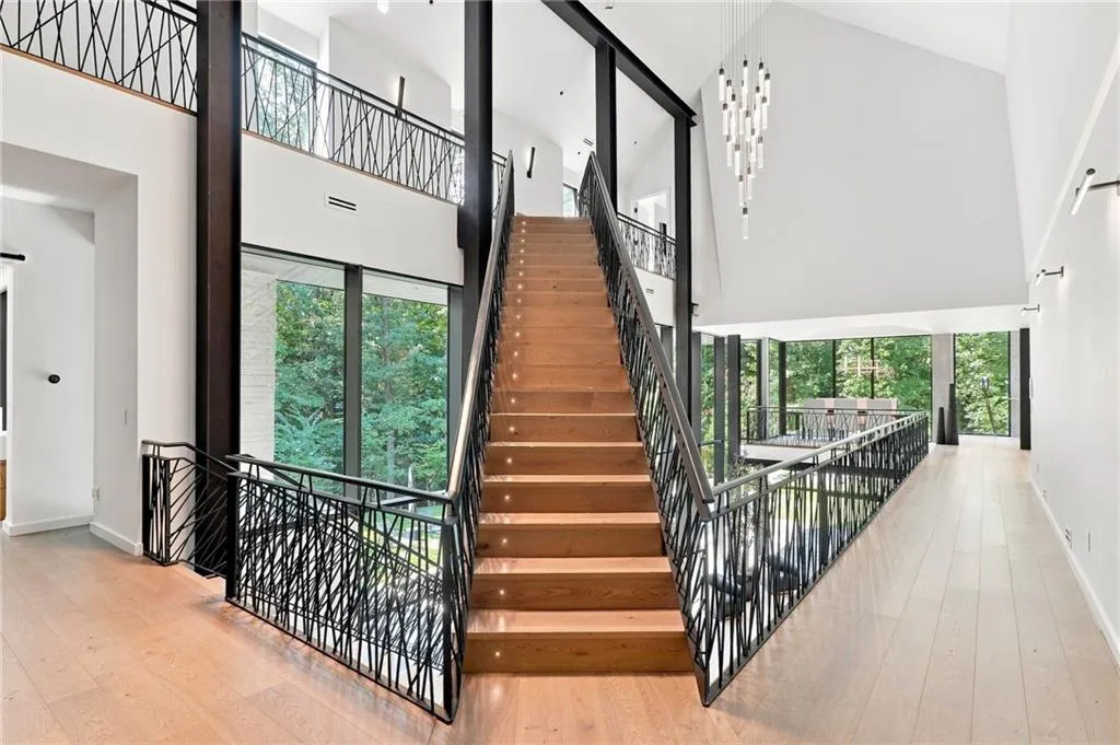 Grand staircase with integrated stair lighting and custom wrought iron railing
