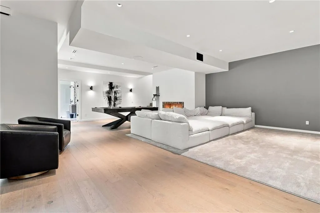 Light wood-finish flooring, recessed lighting, and a modern linear fireplace