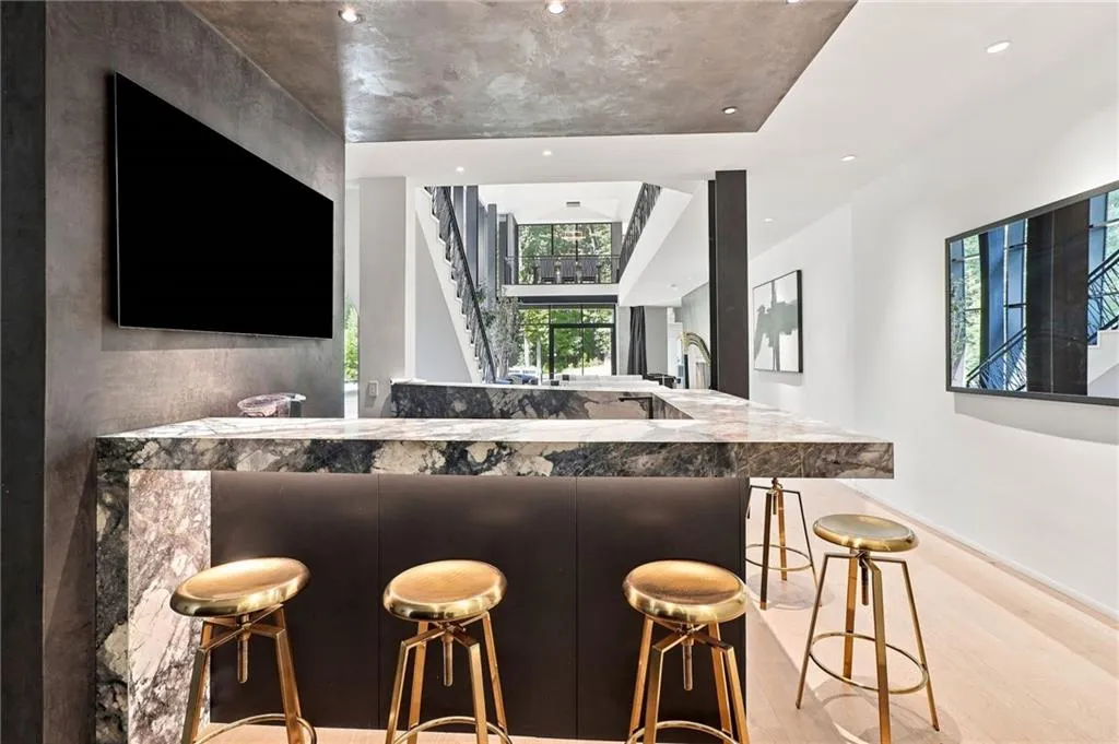 Built-in bar with a stone countertop and waterfall edge, integrated cabinetry, and recessed lighting