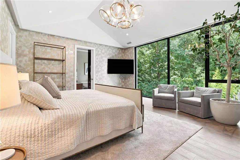 Vaulted ceiling with a contemporary chandelier, floor-to-ceiling windows, wood-finish flooring, and recessed lighting
