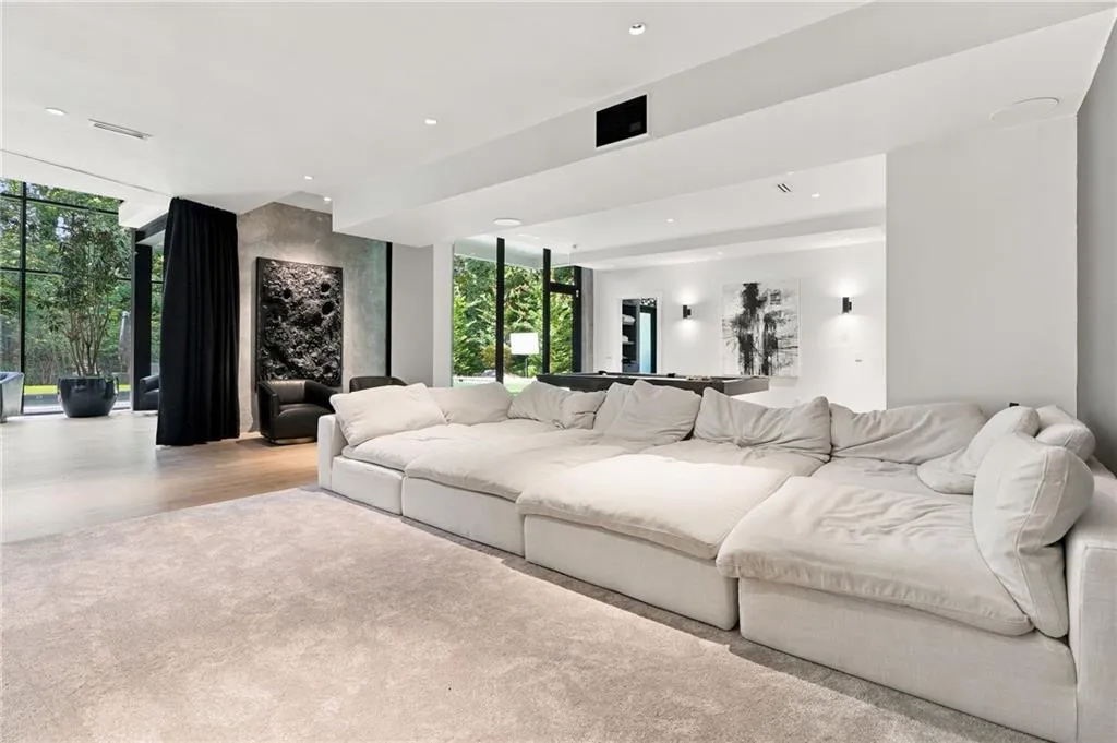 Expansive open-concept room featuring wide plank flooring, recessed lighting, and floor-to-ceiling windows