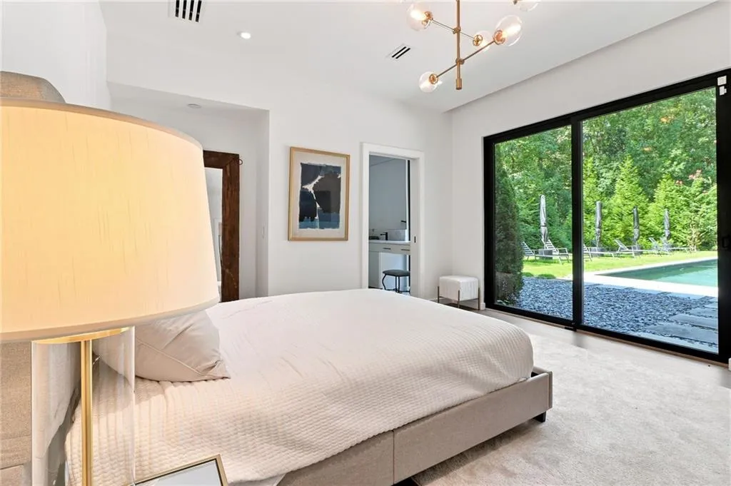 Expansive sliding glass doors, contemporary chandelier, recessed lighting, and soft carpet flooring