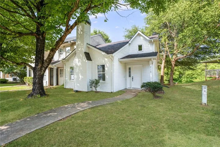 White siding exterior with a prominent chimney structure
