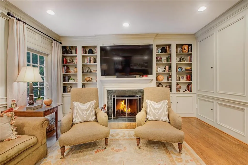 Sitting room featuring a fireplace, built in shelves, and light hardwood / wood-style flooring