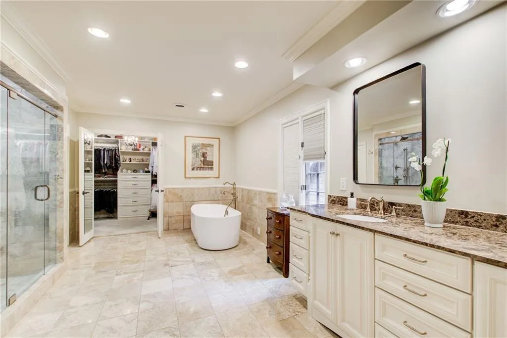 Custom cabinetry, free standing bathtub, glass door shower and  a custom closet.