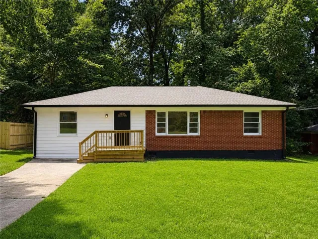 Ranch-style exterior featuring a new front porch and steps, a dark asphalt shingle roof, a section of brick facade, and a section of white siding