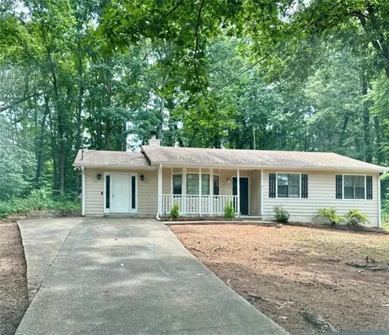 Ranch-style exterior with beige siding and dark shutters