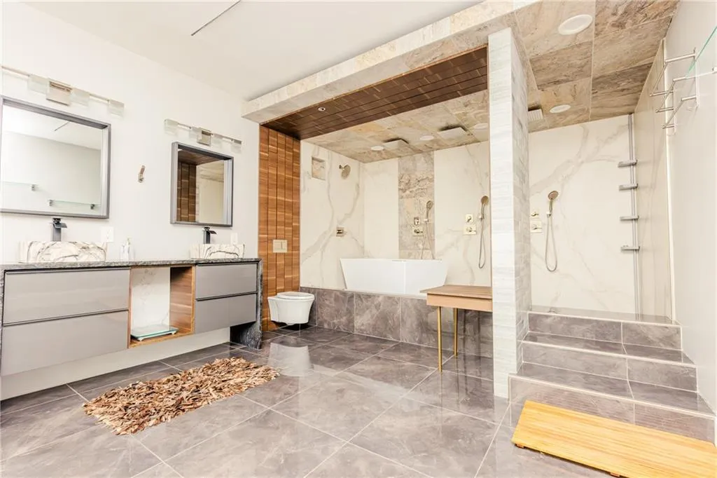 Bathroom with a marble finish shower, double vanity, and marble tiled flooring