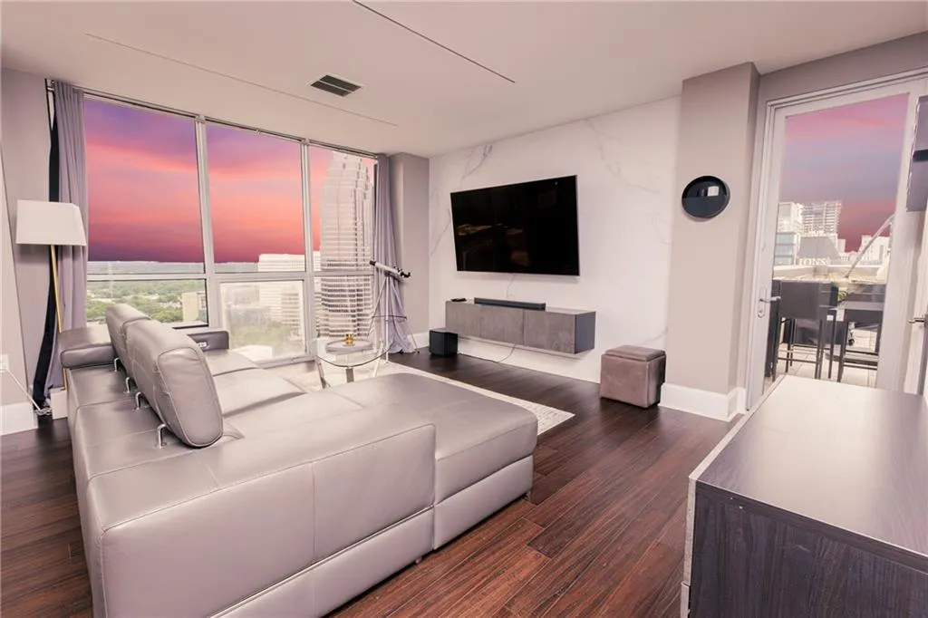 Living room featuring dark wood-style flooring and floor to ceiling windows