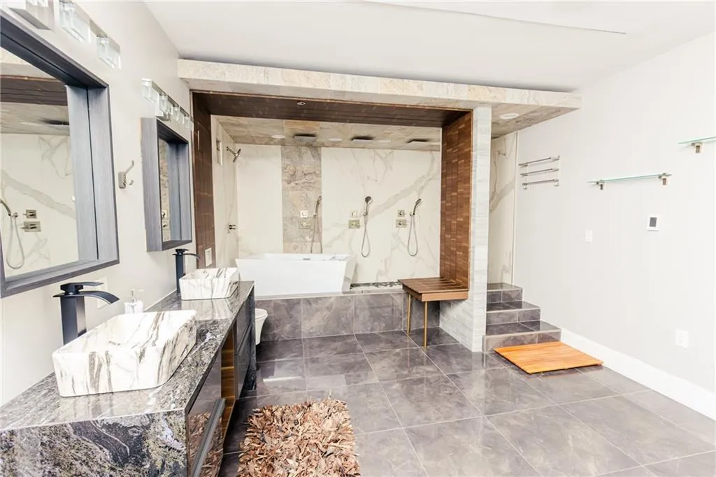 Bathroom with a marble finish shower, vanity, and a bath