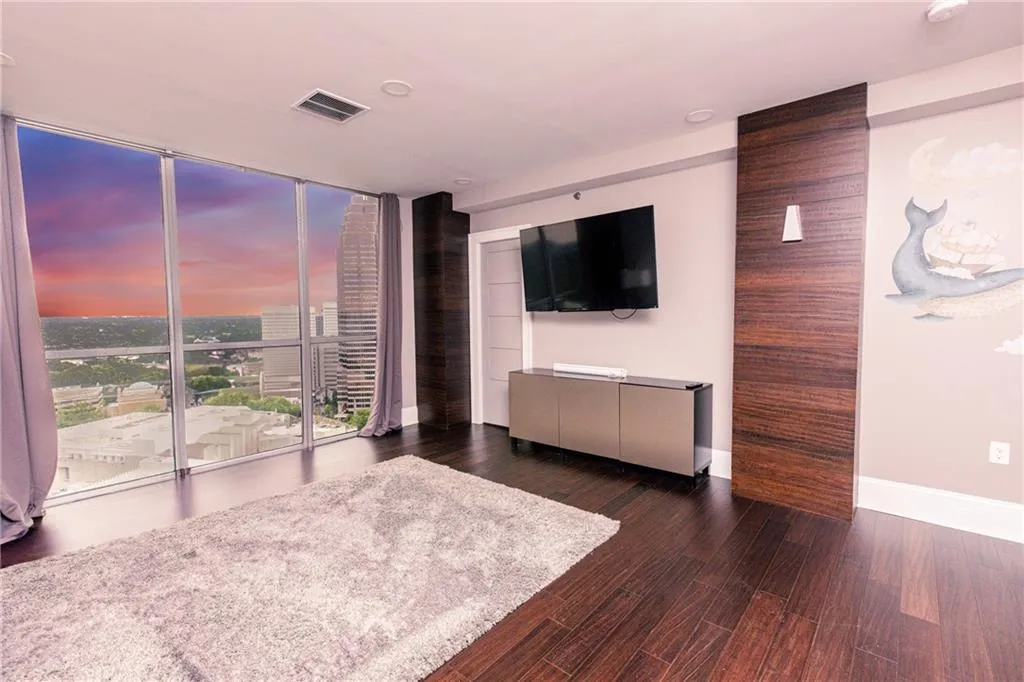 Living area with floor to ceiling windows and wood finished floors