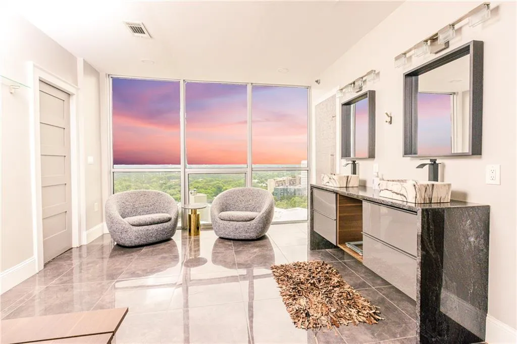 Full bathroom with expansive windows, double vanity, and a freestanding tub