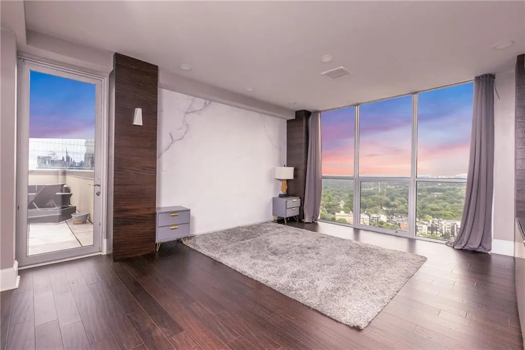 Living room featuring a wall of windows, dark wood-type flooring, and healthy amount of natural light