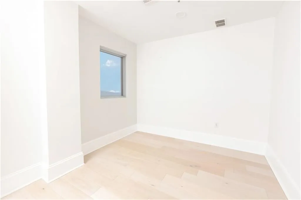 Empty room with light wood-type flooring and baseboards