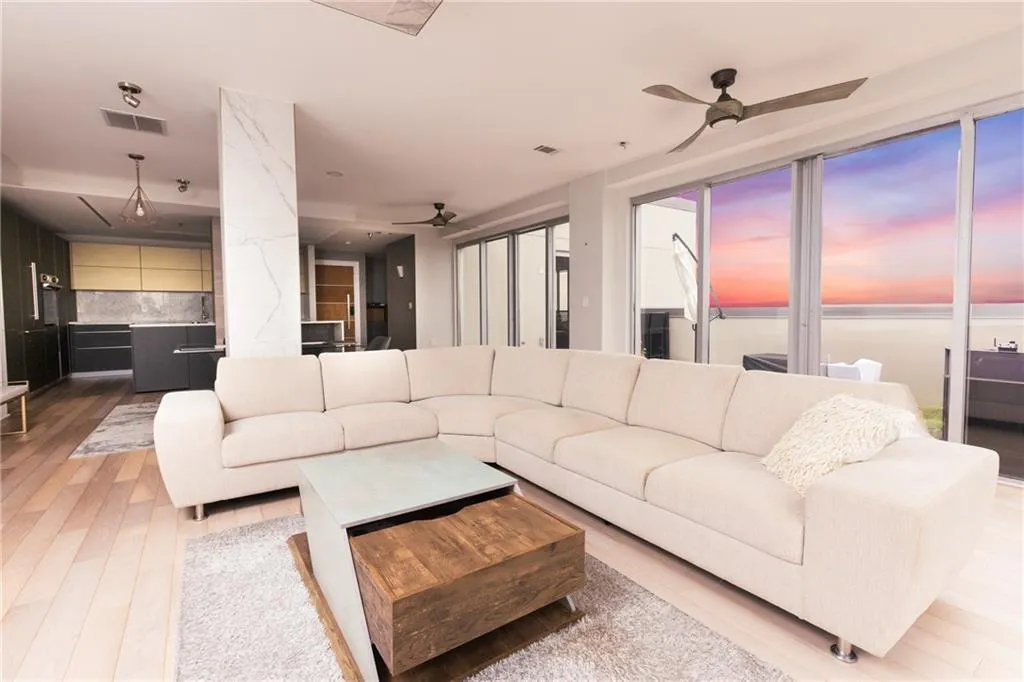 Living room featuring a ceiling fan, light wood-style floors, and plenty of natural light