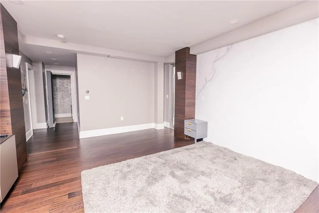 Empty room with dark wood-style floors and recessed lighting