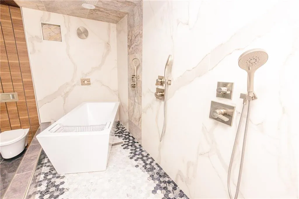Full bath featuring a marble finish shower