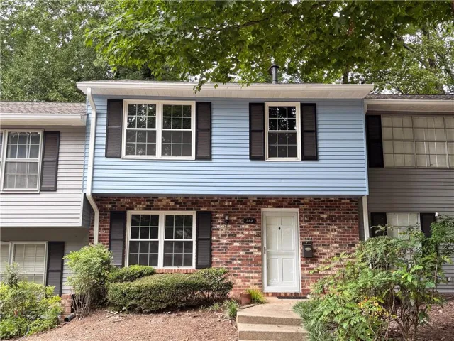 Two-story exterior featuring a brick facade and light blue siding