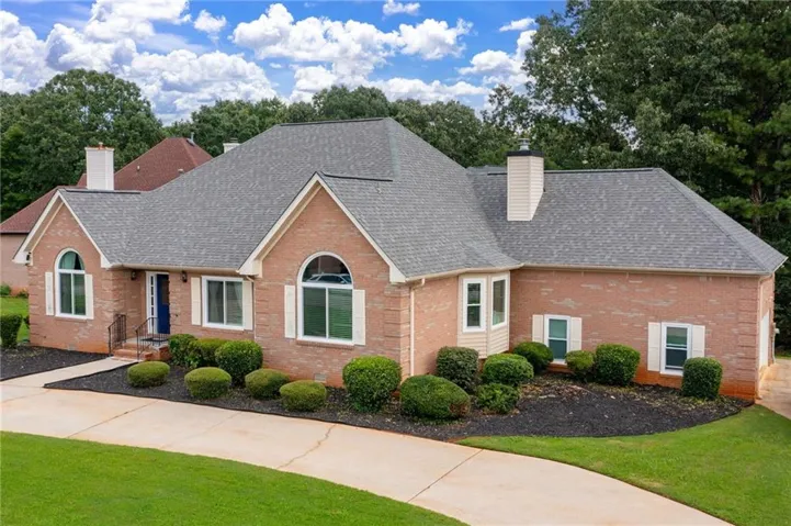 Brick exterior featuring an arched window, a prominent chimney, and a blue entry door
