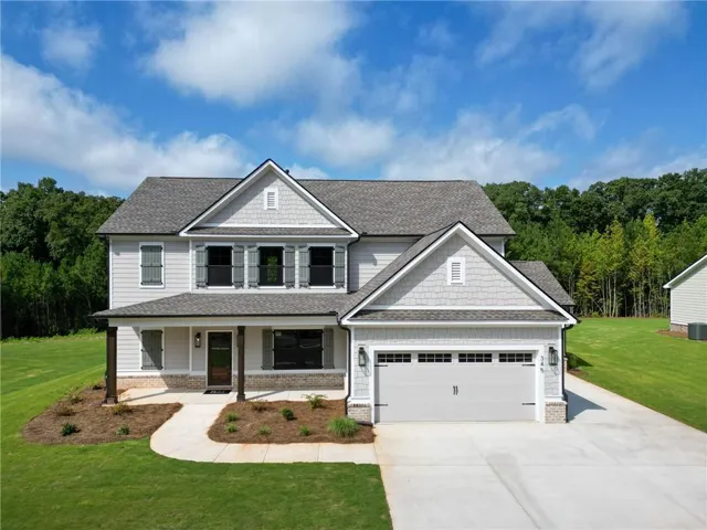 Two-story residence with a covered front porch featuring wood-wrapped columns
