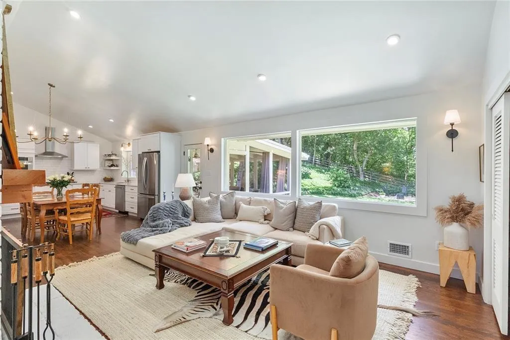 Living area with a chandelier, dark wood-style flooring, recessed lighting, and lofted ceiling