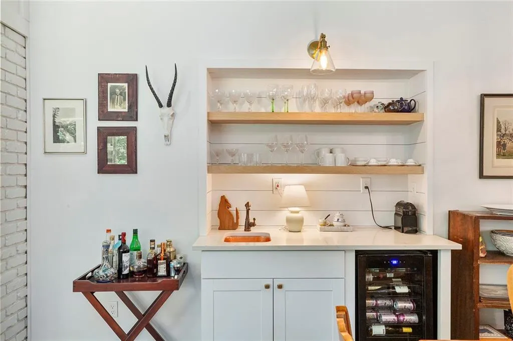 Indoor wet bar featuring wine cooler and tasteful backsplash