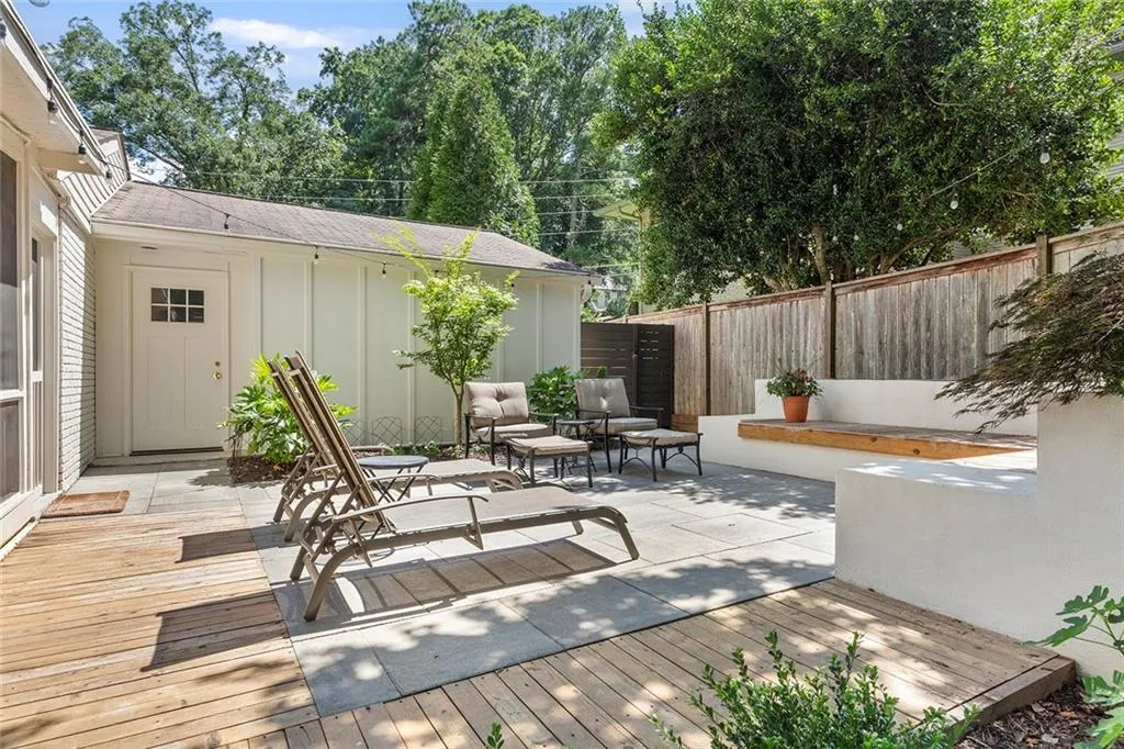Fenced backyard featuring a wooden deck, a patio, and an outdoor hangout area