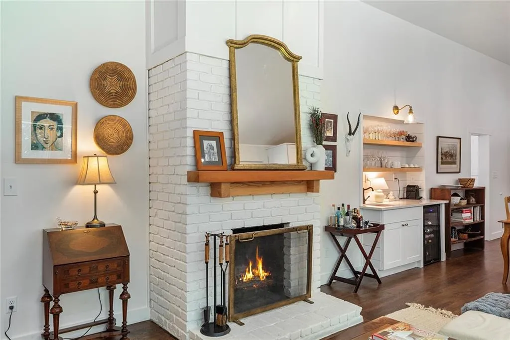 Living room with dark wood-type flooring, a brick fireplace, and wine cooler