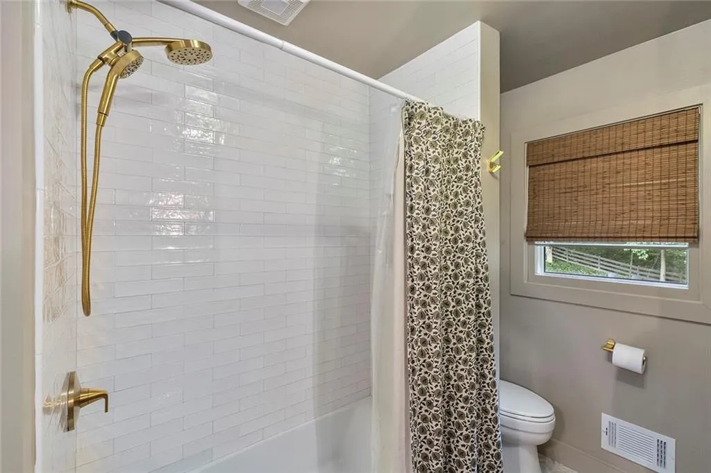 Bathroom featuring shower / bath combo with shower curtain and toilet