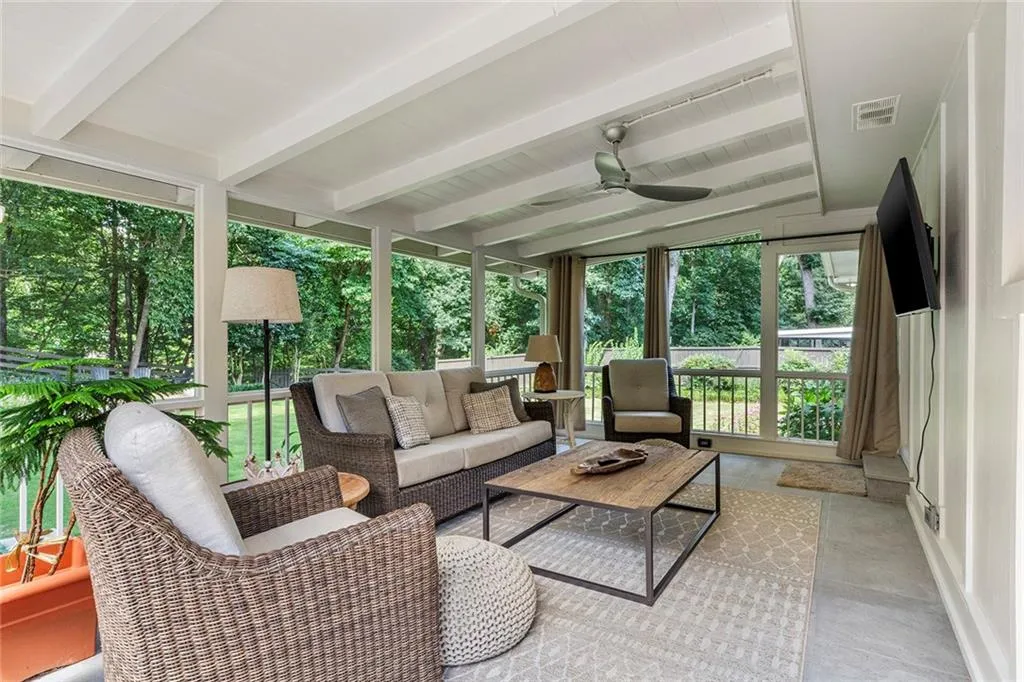 Sunroom with beamed ceiling, ceiling fan, healthy amount of natural light, and an outdoor living space