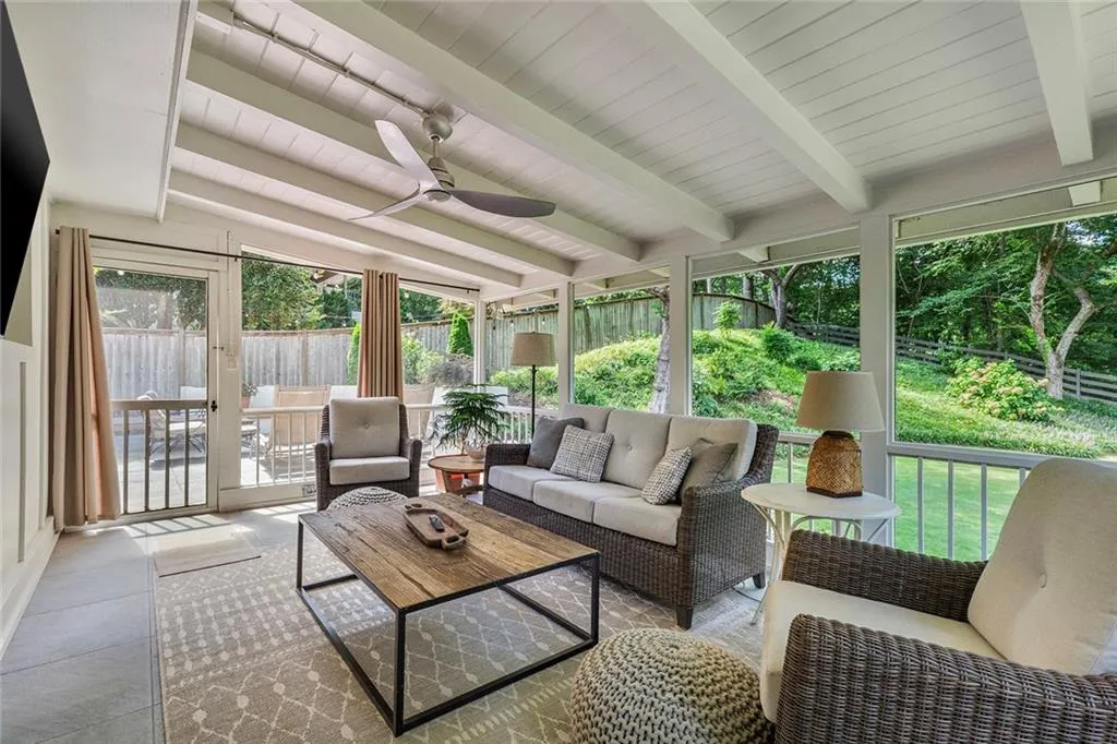 Sunroom with beamed ceiling, a ceiling fan, plenty of natural light, and an outdoor living space