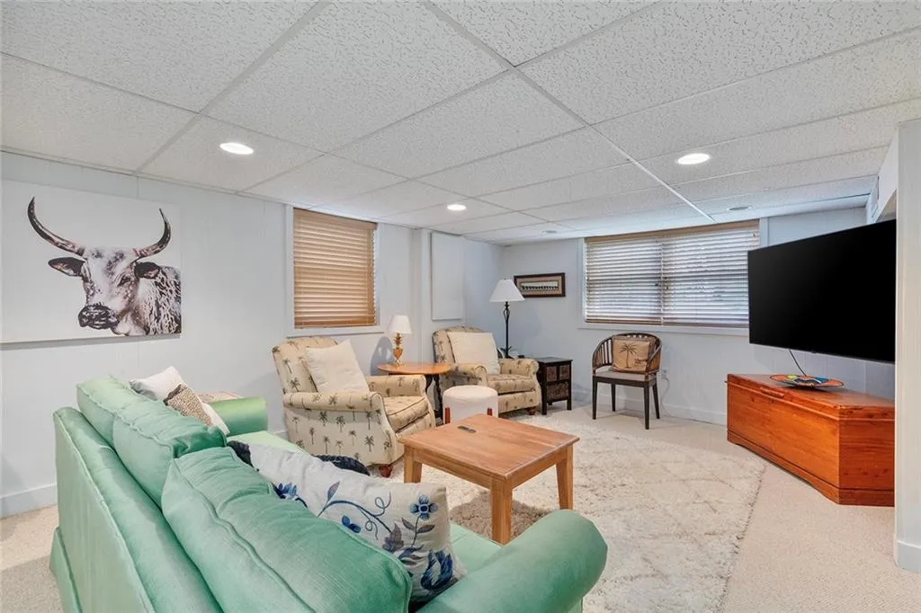 Carpeted living area featuring recessed lighting and a paneled ceiling