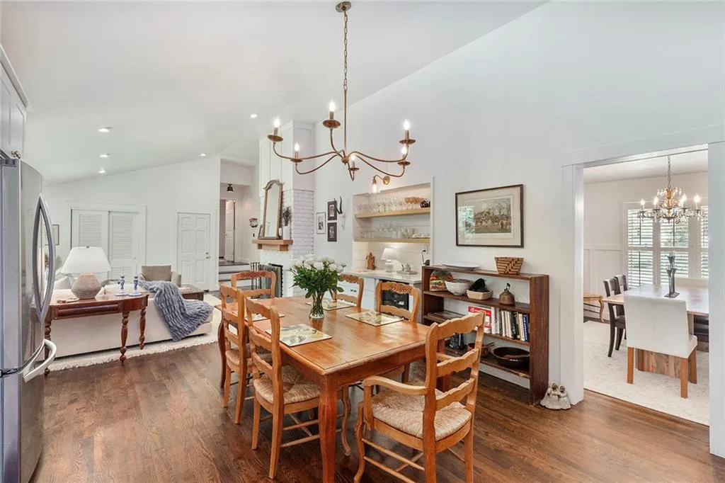 Dining space featuring a chandelier, dark wood finished floors, and high vaulted ceiling
