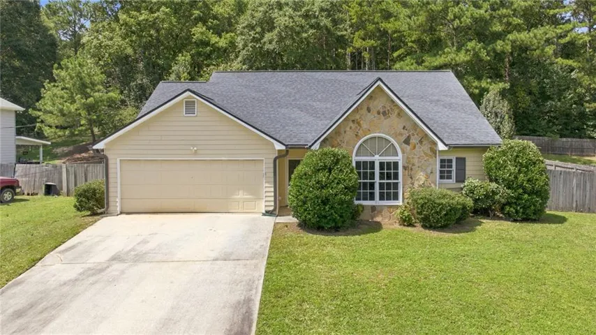 Exterior featuring stone accents, a two-car garage, and a gabled roof