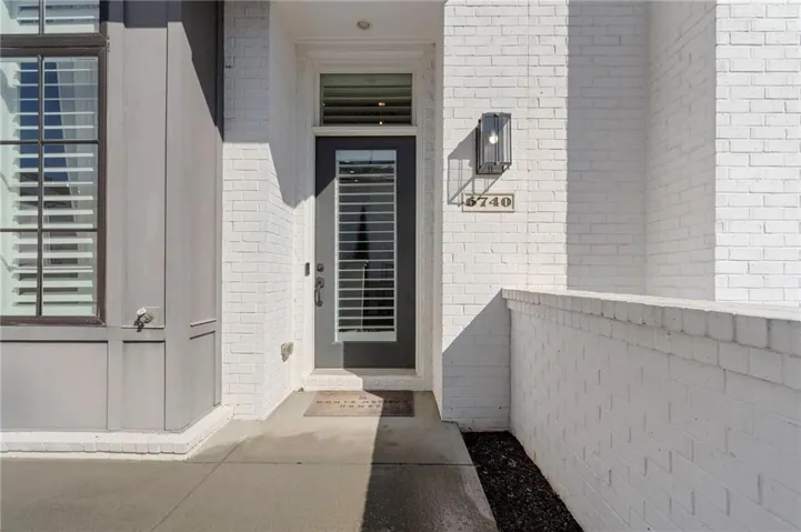 White brick exterior with contrasting gray siding and dark-framed windows