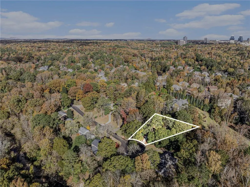 Aerial view of property and surrounding area featuring property boundaries highlighted and a forest