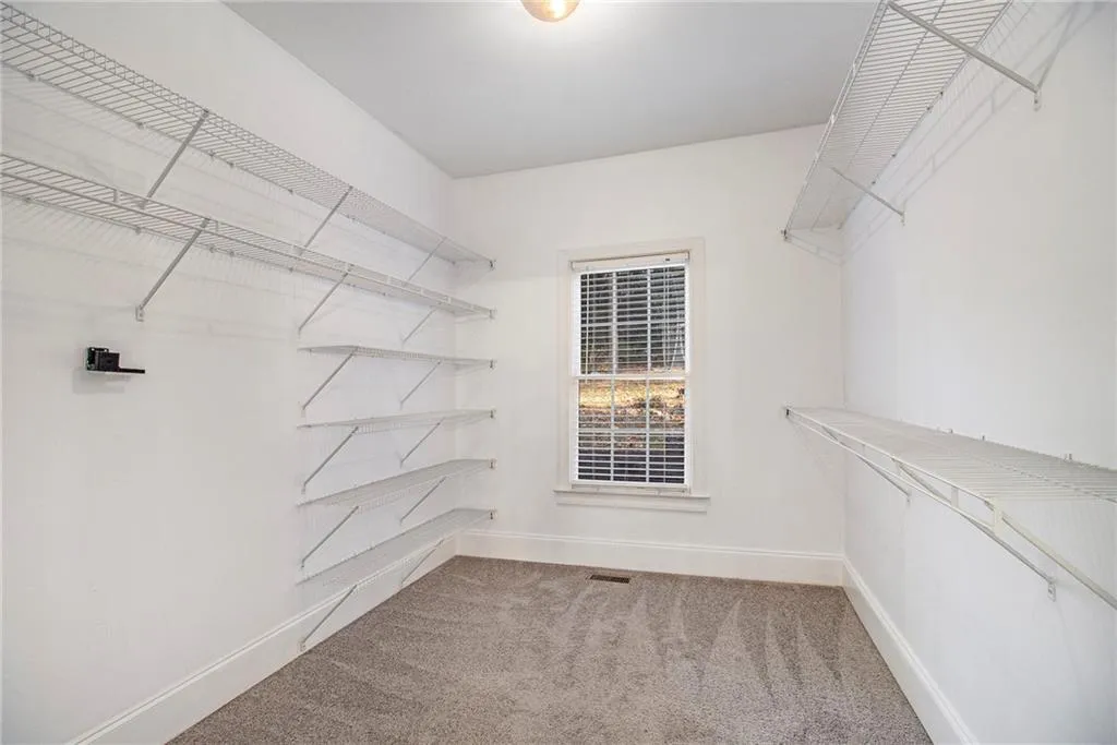 Walk in closet featuring light carpet