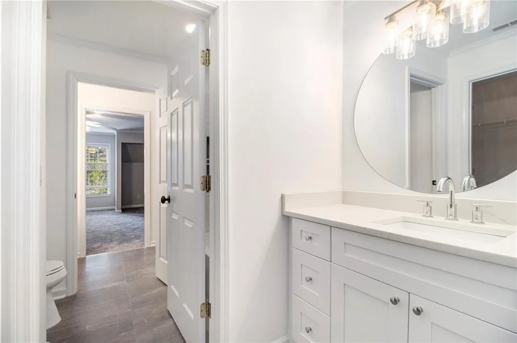 Bathroom with vanity, ornamental molding, and dark tile patterned floors