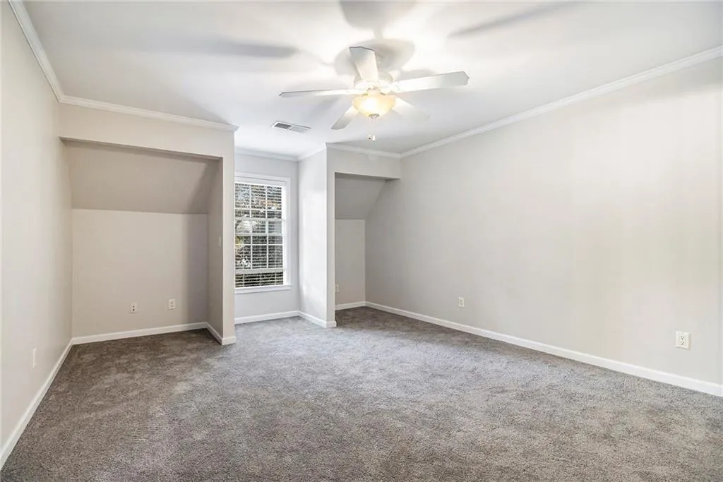 Additional living space with carpet flooring and a ceiling fan