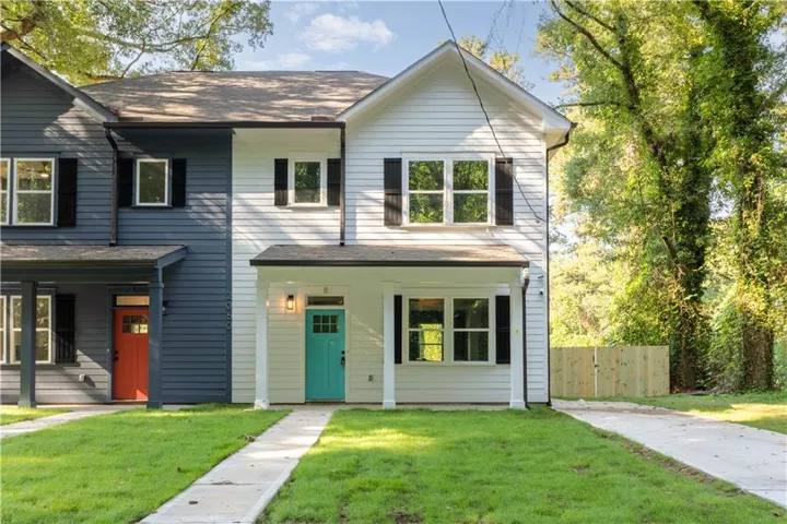 White siding exterior with black shutters and a vibrant teal entry door