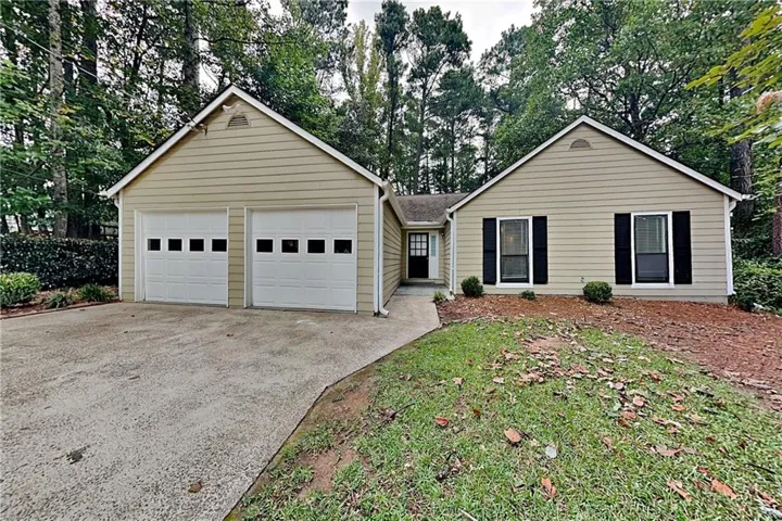 Beige siding exterior with a dual garage featuring white doors