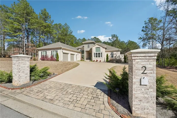 View of front of property with concrete driveway, a garage, and brick siding
