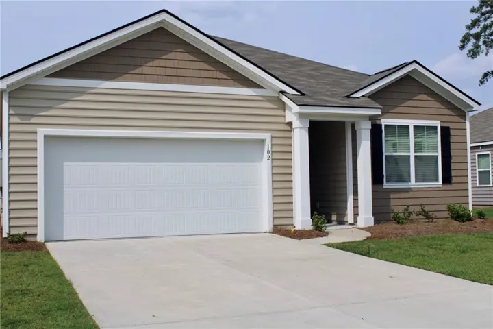 Light-colored horizontal siding, two-car garage, concrete driveway, covered entry with white columns, and dark window shutters