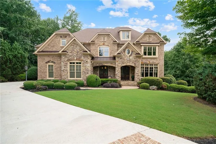 Stone and brick exterior with multiple gables and dormer windows